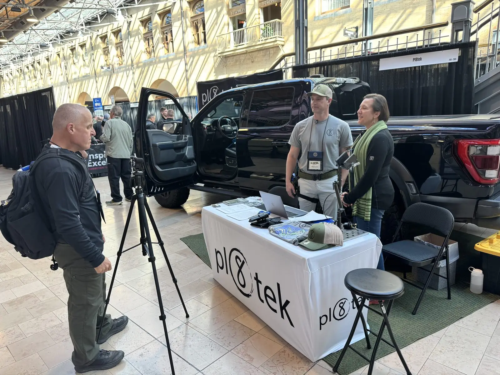 A videographer filming a walkthrough at the Pl8tek booth.